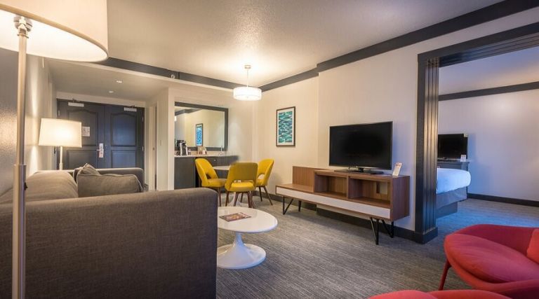 Living room, pull out sofa, flat screen TV, table and chairs.